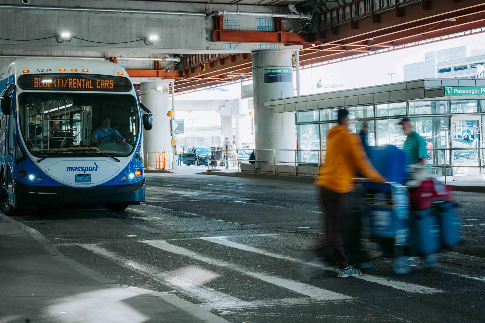 אוטובוס הסעה של חברת השכרת רכב ונוסעים עם מזוודות במתחם שדה תעופה