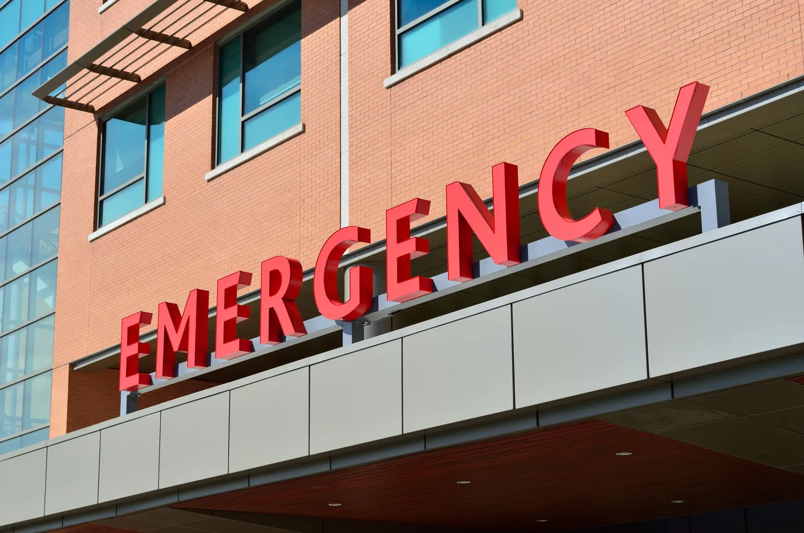 שלט אדום גדול עם הכיתוב Emergency על קיר בית חולים